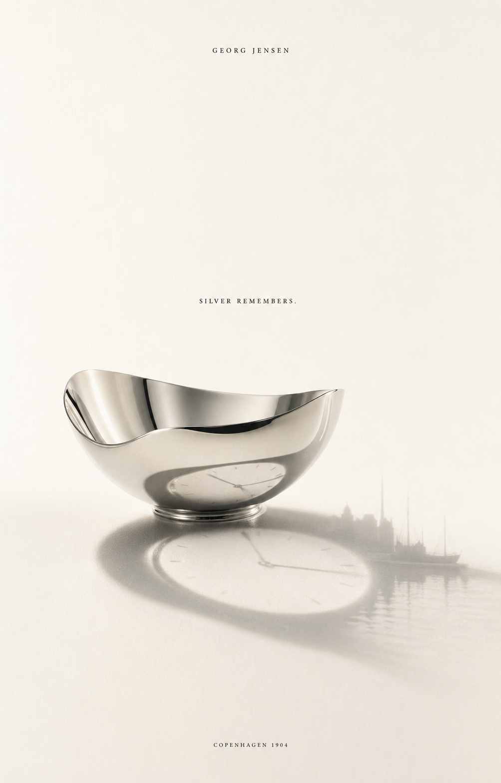 A polished sterling silver bowl reflecting a faint Copenhagen skyline on a soft cream surface